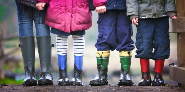 four children standing on dirt during daytime